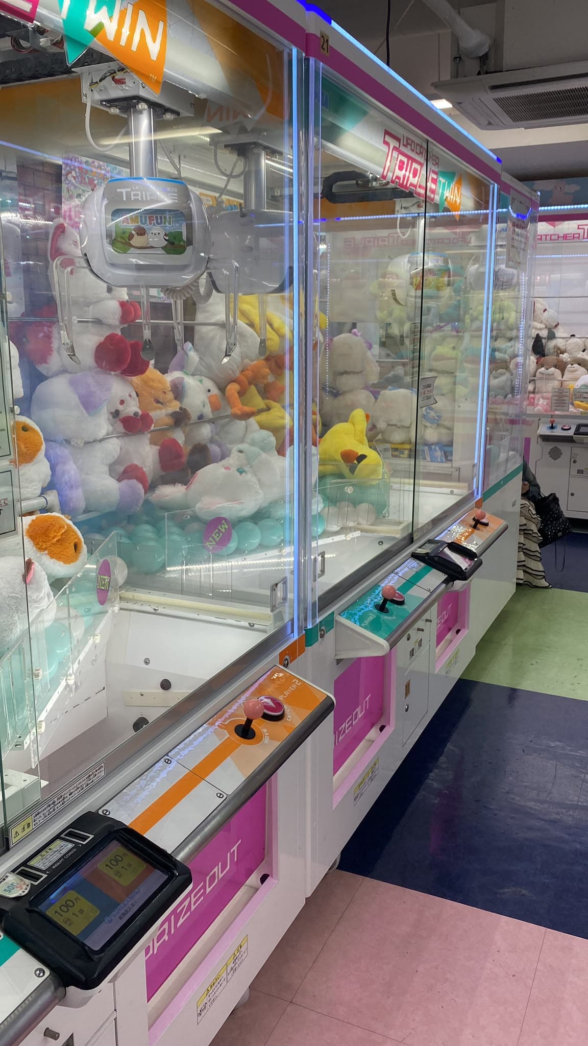 Parada entre máquinas recreativas y peluches en la noche de Tokio.