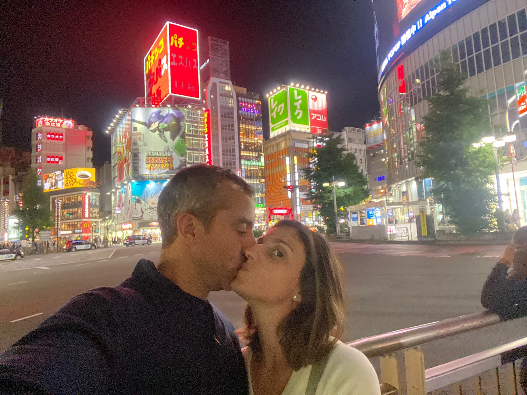 Beso en mitad de Shinjuku, con la ciudad encendida alrededor.