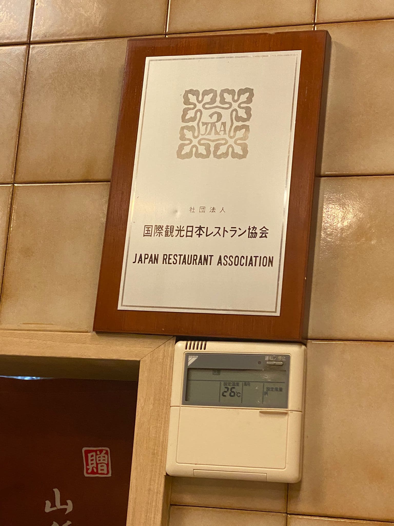 Placa de la Japan Restaurant Association en el restaurante.