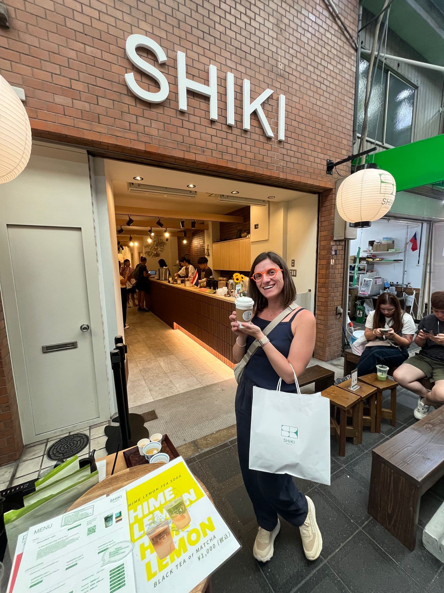 África posando con su bebida de matcha frente al local de SHIKI.