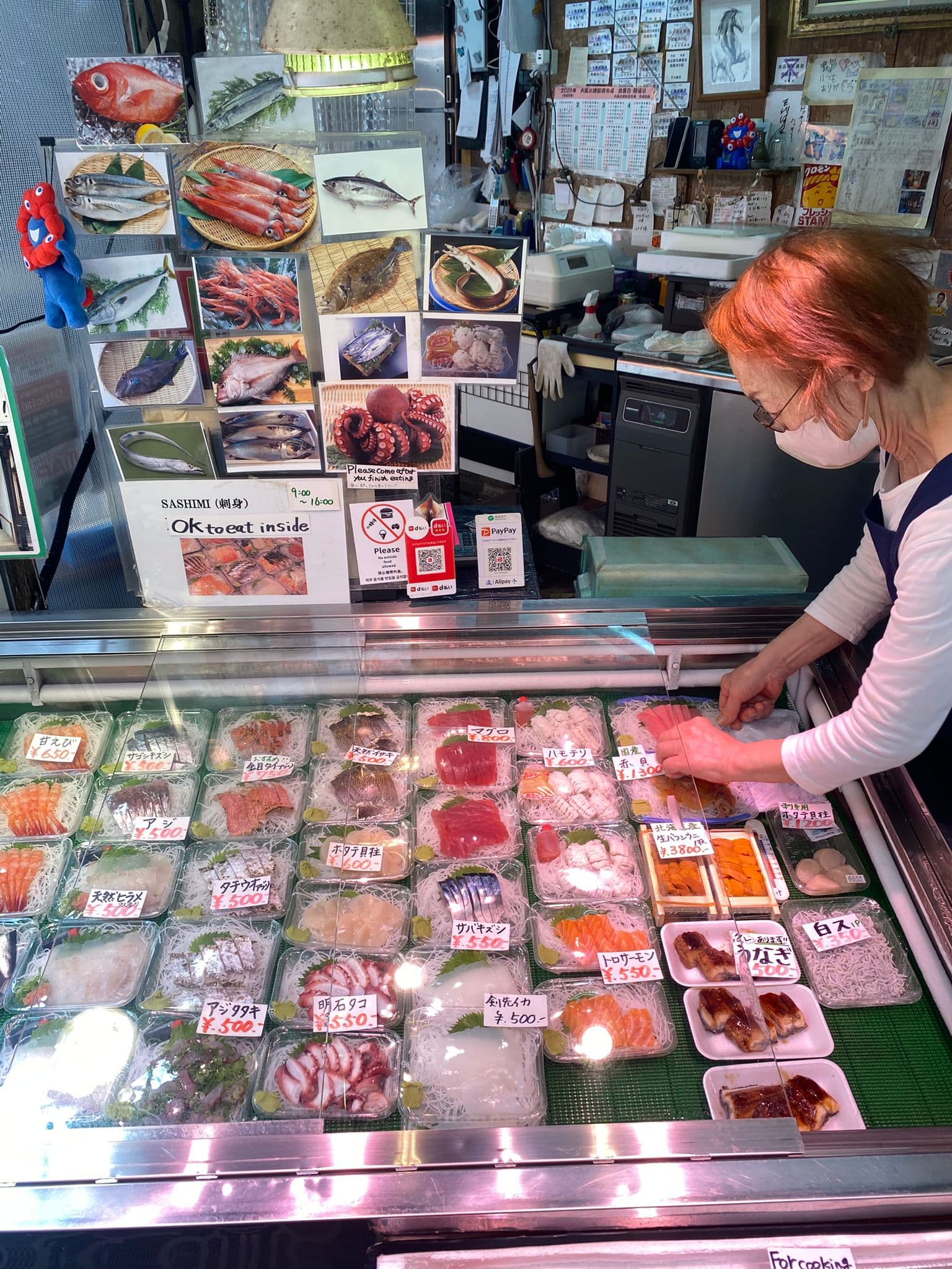 Bandejas de sashimi preparadas en un puesto del mercado.